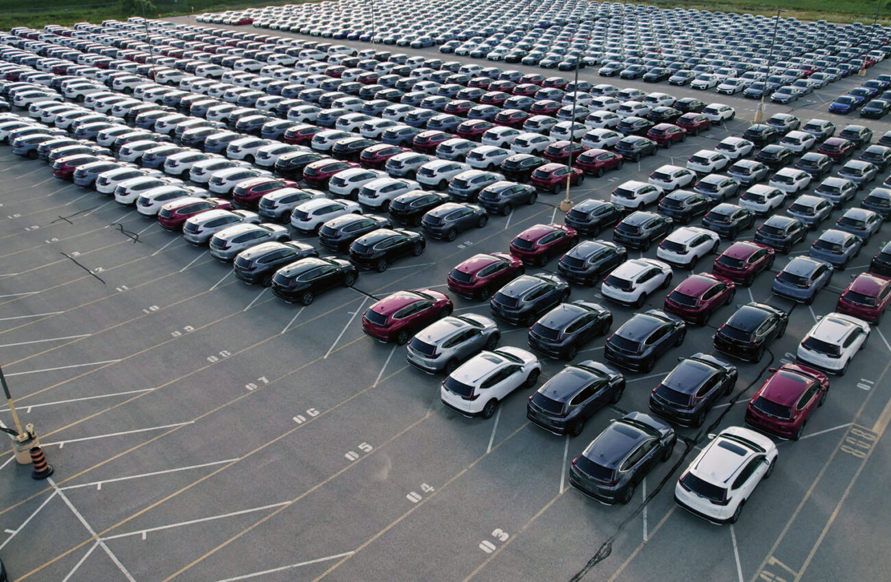 Aerial view of car storage or parking lot new unsold EV cars. Ve
